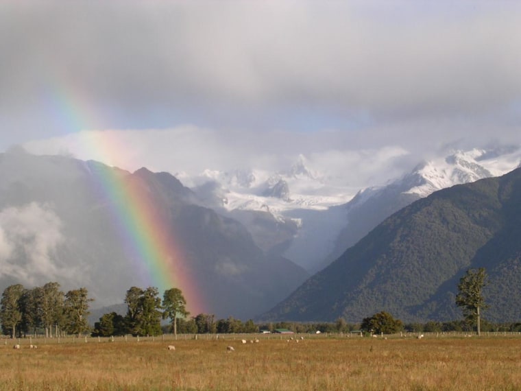 Rainbow captured on a sheep farm outside Greymouth, New Zealand, in December 2003. The Franz Josef glacier is in the background.