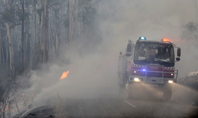 Fire crews drive through smoke from backburning operations near Jamieson, Australia, on Tuesday.