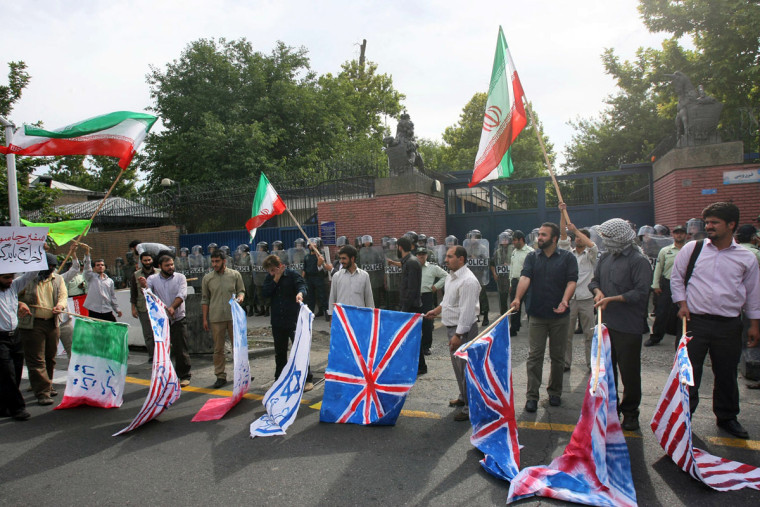 Supporters of Iran's government protest outside the British Embassy in Tehran on Tuesday, later burning the British, U.S. and Israeli flags.