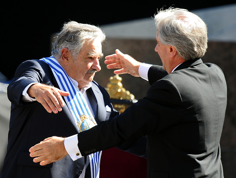 Uruguayan President Jose "Pepe" Mujica, left, embraces outgoing President Tabare Vazquez after receiving the ceremonial sash at a ceremony in Montevideo on Monday. 