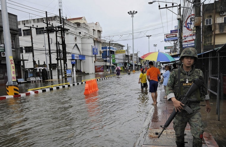Image: A Thai soldier (R) patrols along a flood