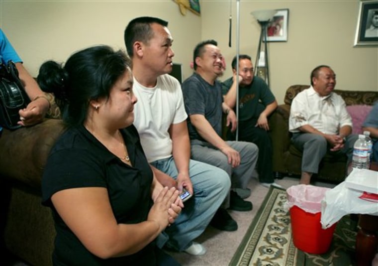 Pa Phang, left, and her husband Chu Vang, second from left, talk with relatives during a wake in honor of Vang's father Xee Hue Vang in Sacramento, Calif., on Tuesday, Oct. 7, 2008. Xee Hue Vang, 83, was one of seven killed when a tour bus crashed on it's way to a casino north of Sacramento. 