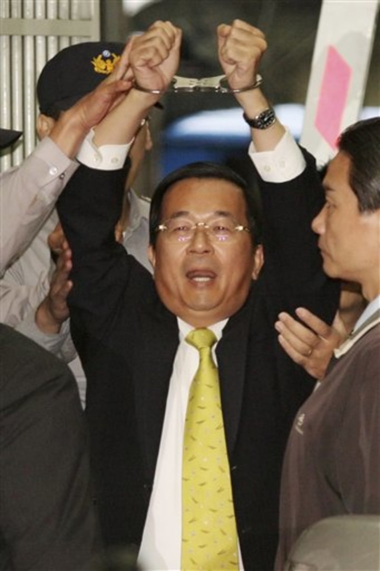 The former president of Taiwan, Chen Shui-bian, displays his handcuffs Tuesday while leaving the prosecutors' office in Taipei.