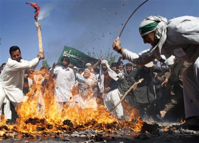 Afghan protestors beat a burning effigy of U.S. President Barack Obama during a demonstration in Jalalabad on Sunday.