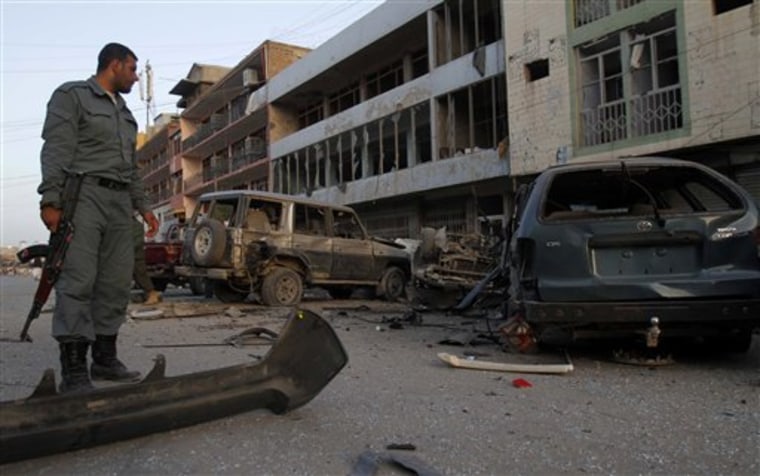 An Afghan police officer inspects the site of a car bomb blast outside a hotel in the southern Afghan city of Kandahar on Thursday. A later explosion reportedly killed six people.