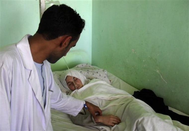 A medic at the hospital in Kunduz, Afghanistan, checks on one of the hospitalized schoolgirls. 