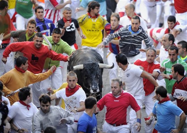 A bull and runners are seen during the Festival of San Fermin, in Pamplona, Spain.