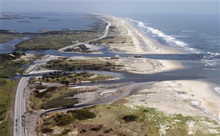 Officials survey the damage to Highway 12 on Sunday on Hatteras Island, N.C., after Hurricane Irene swept through the area, washing out the road in five locations. 