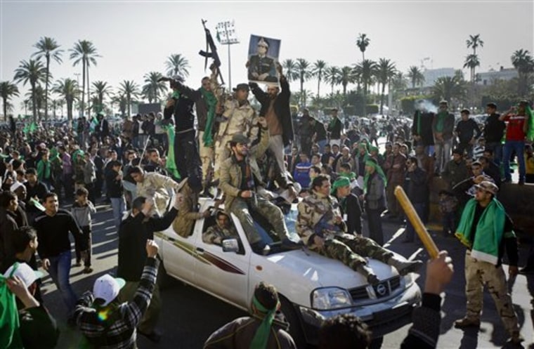 Pro-Gadhafi soldiers and supporters gather in Green Square in Tripoli, Libya on Sunday. Thousands of Moammar Gadhafi's supporters poured into the streets of the capital, waving flags and firing their guns in the air in the Libyan leader's main stronghold, claiming overnight military successes. 