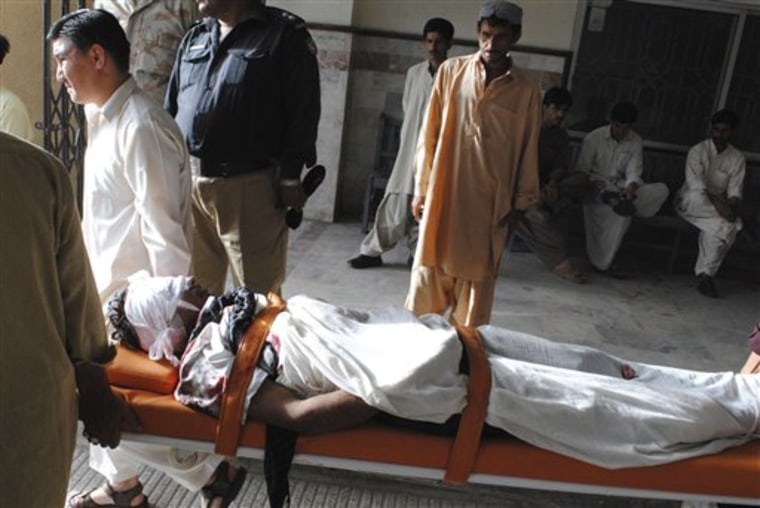 People carry the dead body of their family member who was shot dead by gunmen, in Quetta, Pakistan on Friday, July 29, 2011. Unidentified gunmen have killed seven passengers at a bus terminal in southwest Pakistan, police  said and injured another 12. Baluchistan is home to a small separatist movement that often targets Pakistanis from other parts of the country living there. Many non-Baluch have left as a result. (AP Photo/Arshad Butt)