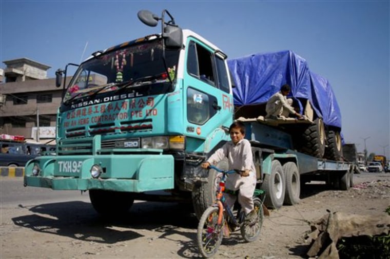 A Pakistan child pedals past a truck, carrying supplies for NATO forces, parked on the roadside in Peshawar, Pakistan on Saturday. Some 150 trucks were still waiting for Pakistan to reopen the border crossing at Torkham so they could deliver their supplies to Western troops in Afghanistan. 