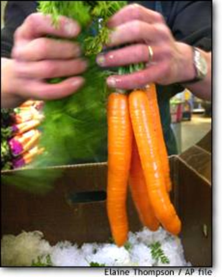 Dan Johnson, produce coordinator at the Puget Consumers Co-op in Seattle's Greenlake neighborhood, bundles organic carrots.