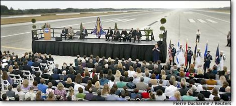 NASA workers attend a memorial service for the Columbia astronauts on a runway at the Kennedy Space Center in Cape Canaveral, Fla.