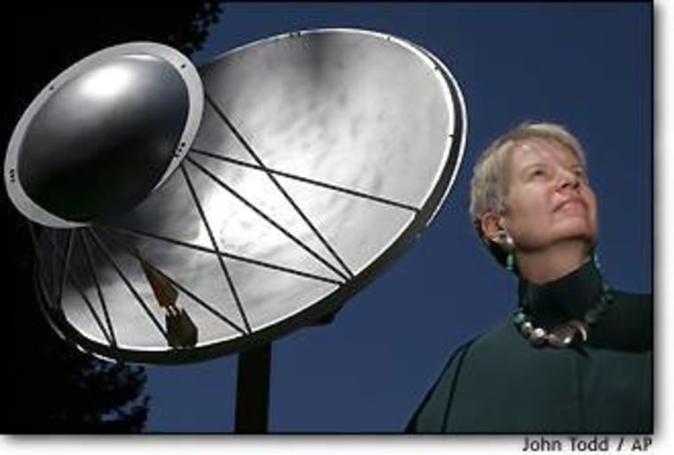 Jill Tarter, director of the Center for SETI Research, stands alongside a one-eighth-scale model of an antenna for the Allen Telescope Array. Within four years, 350 of the full-size antennas are to be deployed in Hat Creek, Calif.