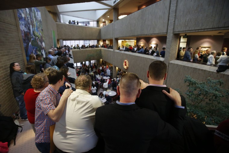 Same-sex couples, accompanied by their friends and family members, line up to get marriage licenses at the Salt Lake County clerk's office Monday, December 23, 2013.