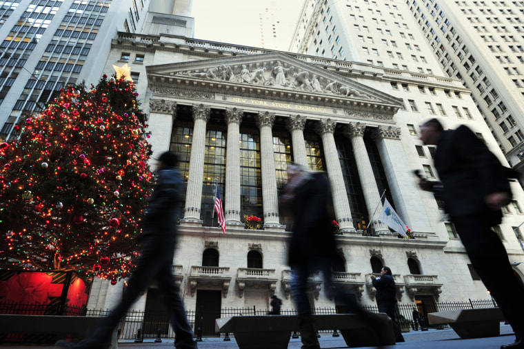 People walk by a Christmas tree in front of the New York Stock Exchange, Dec. 24, 2013 in New York.