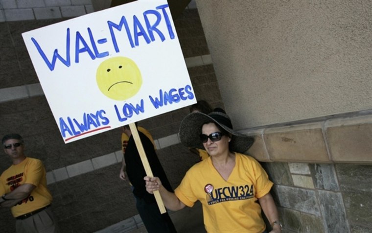 Diana Huffman holds a sign in support of striking Walmart workers protesting unsafe working conditions and poor wages outside a Walmart store in Pico Rivera, California, October 4, 2012.