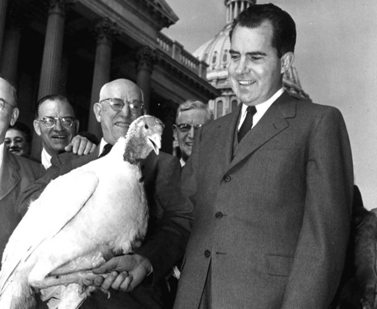 Vice President Richard Nixon \"shakes hands\" with a 40-pound white turkey on November 14, 1955, at the Capitol in Washington, D.C. The big bird was not pardoned, but was destined for President Eisenhower's Thanksgiving dinner. (AP Photo/William J. Smith)