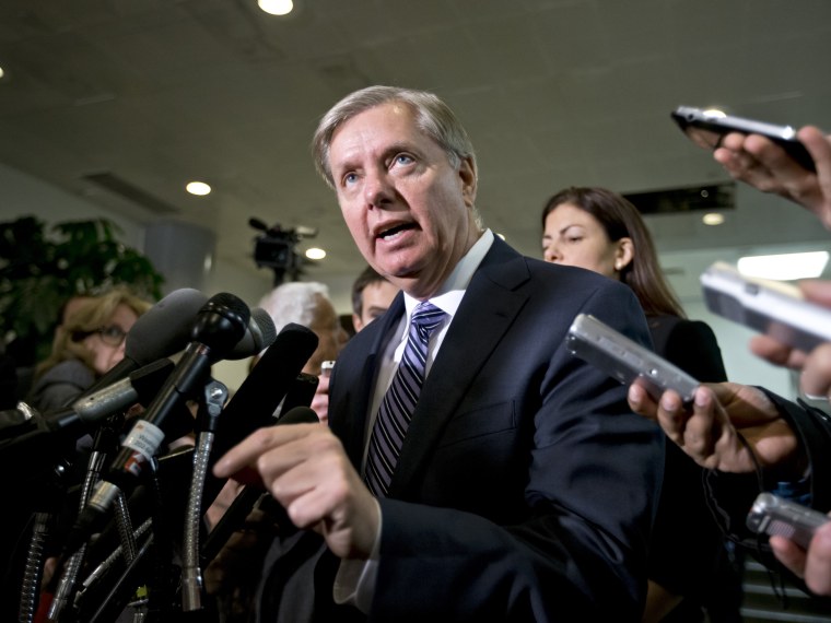Sen. Lindsey Graham, R-S.C., a member of the Senate Armed Services Committee and the Senate Homeland Security Committee, center, accompanied by fellow Senate Armed Services Committee member, Sen. Kelly Ayotte, R-N.H.,, right, gestures while speaking to...