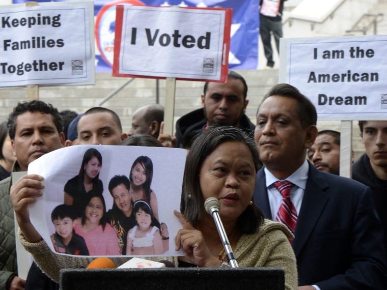 Lolita from the Philippines holds a photograph of her family as she joined other immigrants who gathered in front of Los Angeles City Hall to press for immigration reform following the re-election of US President Barack Obama in Los Angeles, California...