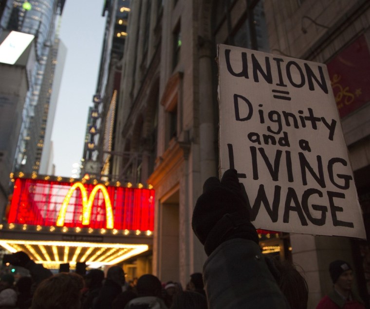 A protester holds up a sign at a demonstration outside McDonald's in Times Square in support of employees on strike at various fast-food chains in New York November 29, 2012. (REUTERS/Andrew Kelly)