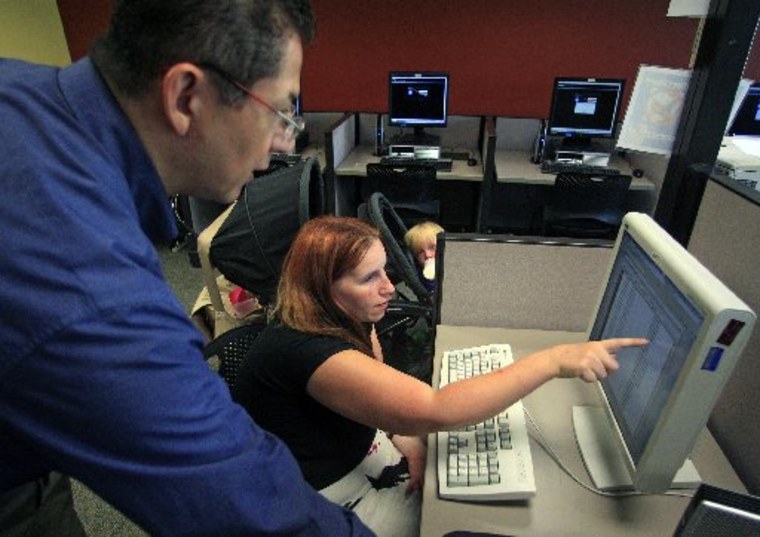 File photo: Deanna Aguilera, 30, of Salt Lake City, right, receives assistance from employment counselor Frank Trivino while job searching at Workforce Services, in Salt Lake City, Sept. 21, 2012. The number of Americans seeking unemployment benefits...
