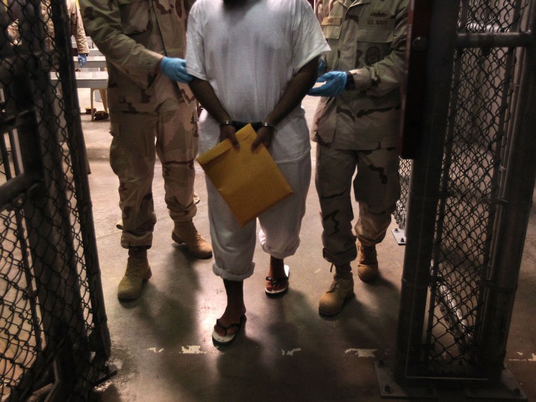 File Photo:  U.S. Navy guards escort a detainee after a \"life skills\" class at Camp 6 in the Guantanamo Bay detention center on March 30, 2010 (Photo by John Moore/Getty Images, File)