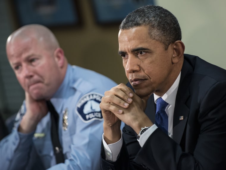 Minneapolis Public Schools School Resource Officer Mike Kirchen (L) and US President Barack Obama listen during a round table discussion at the Minneapolis Police Department's special operations center February 4, 2013 in Minneapolis, Minnesota. Obama...