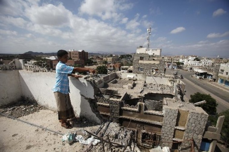 A boy gestures to damage on a house caused by an air strike last year that was targeting al Qaeda-linked militants in Yemen on February 1, 2013.  (YEMEN - Tags: POLITICS CIVIL UNREST MILITARY)