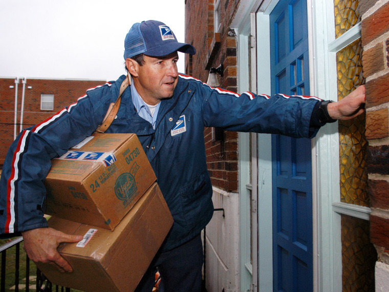 File Photo: U.S. Postal Service carrier Ron Comly carries parcel packages to a home while delivering mail along his postal route December 17, 2003 in Philadelphia, Pennsylvania. December 17 that year was expected to be the busiest delivery day for the...