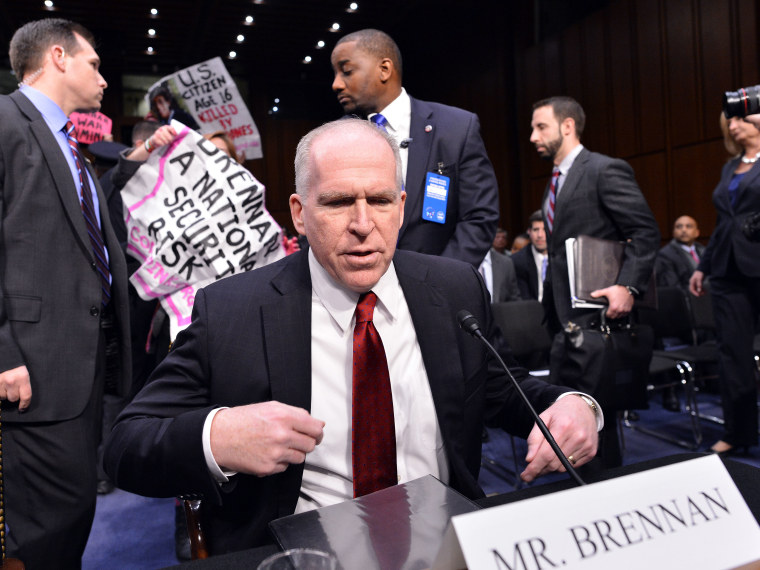 Anti-war protesters shout slogans as John Brennan (R), President Barack Obama's pick to lead the CIA, arrives to testify before a full committee hearing on his nomination to be director of the Central Intelligence Agency  (CIA) in the Hart Senate...