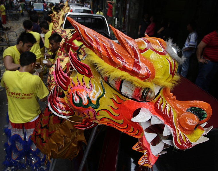 Dragon dancers take a break after performing in front of Chinese business establishments on the eve of Chinese New Year celebration Saturday Feb. 9, 2013 at Manila's Chinatown district of Binondo in Manila, Philippines. This year marks the Year of the...