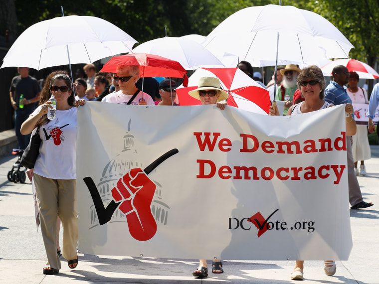 File Photo: Members of D.C. Vote and the League of Women Voters demonstrate in front of the White House to honor the 90th anniversary of the 19th Amendment guaranteeing women the right to vote August 26, 2010 in Washington, DC. The demonstrators also...