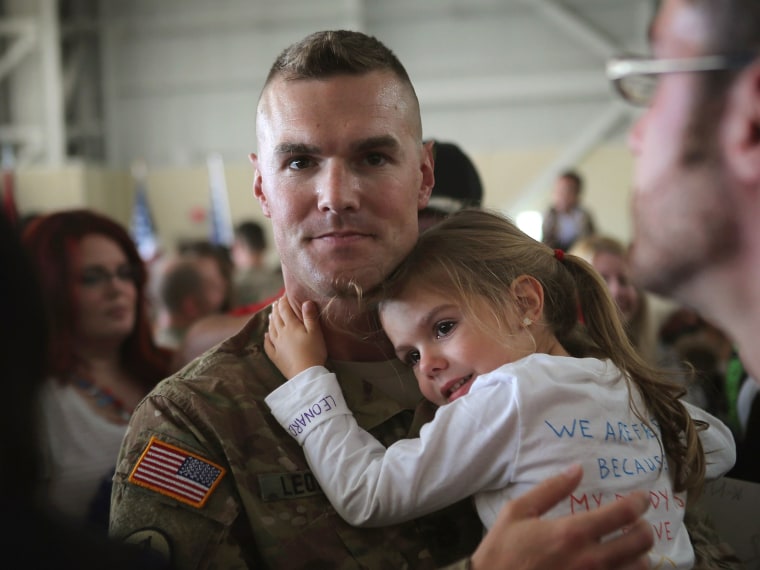 Haley Leonard holds on to her father SFC Kyle Leonard after he arrived at a homecoming ceremony with his unit, the 713th Engineer Company of the Indiana Army National Guard, at the Army Aviation Support Facility on September 26, 2012 in Gary, Indiana....