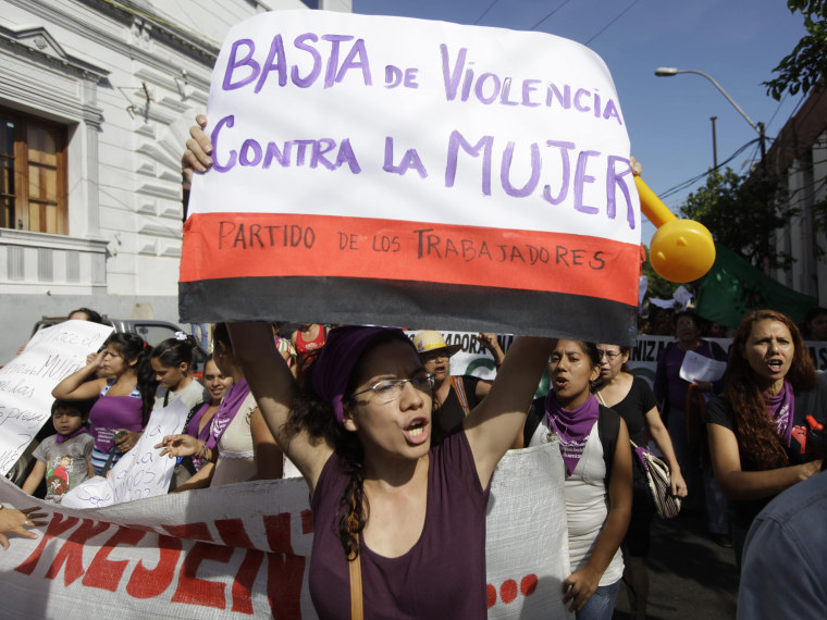 International Women's Day in Asuncion, Paraguay, Friday, March 8, 2013. The poster reads in Spanish \"Enough violence against women.\" (Photo by Jorge Saenz/AP Photo)