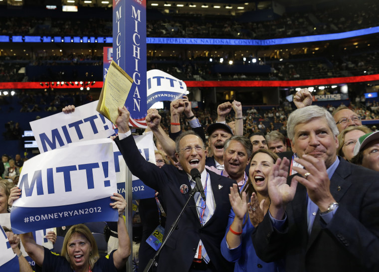 Michigan delegate Scott Romney, center with a note pad, and the rest of Michigan delegates react at the Republican National Convention in Tampa, Fla., on Tuesday, Aug. 28, 2012. At right is Michigan Gov. Rick Snyder. (AP Photo/Charles Dharapak)
