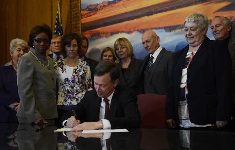 Colorado Governor John Hickenlooper signs three gun control bills into law in his office at the state capitol in Denver, Colorado, March, 20, 2013. The three gun control bills include one banning ammunition magazines with more than 15 rounds in a state...