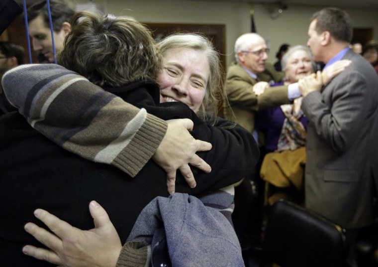 C. Kelly Smith, of Providence, R.I., center, a member of Marriage Equality Rhode Island, hugs fellow member Wendy Becker, left, also of Providence, after a house committee vote on gay marriage at the Statehouse, in Providence, Tuesday, Jan. 22, 2013....