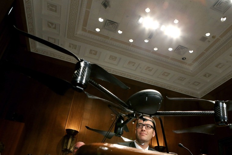 Mesa County Sheriff's Office Unmanned Aircraft Program Manager Benjamin Miller testifies before the Senate Judiciary Committee while framed by a Draganflyer X6 remote-controlled  miniature helicopter in the Dirksen Senate Office Building on Capitol...