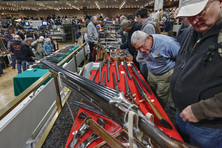 David Petronis of Mechanicville, NY, upper left, owner of a gun store, talks with a potential customer at his table during the  annual New York State Arms Collectors Association Albany Gun Show at the Empire State Plaza Convention Center, on Saturday,...