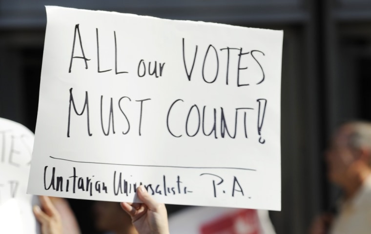 Emily Goldberg and her daughter Willa, 2, holds up a sign during the NAACP voter ID rally to demonstrate the opposition of Pennsylvania's new voter identification law, Thursday, September 13, 2012, in Philadelphia.