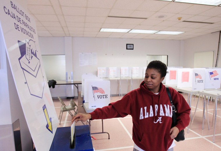 Sheenae Westmoreland drops her ballot into the box after voting at the Cuyahoga County Board of Elections Tuesday, Jan. 31, 2012, in Cleveland.