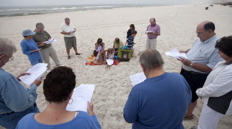 People gather in prayer at dawn during a prayer vigil in Orange Beach, AL for those who suffered following the Deepwater Horizon incident.