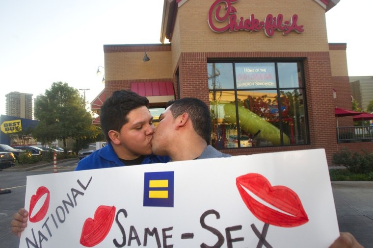 Miguel Martinez, left, kisses partner of five years, Sergio Andrade, right, during National Same Sex Kiss Day at Chick-fil-A in Houston on Aug. 3, 2012.