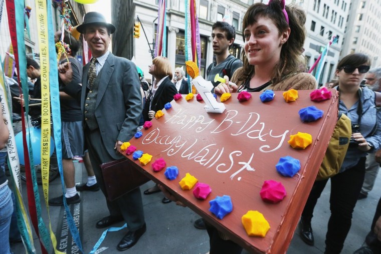 A protester affiliated with Occupy Wall Street holds a sign fashioned as a birthday cake on September 17, 2012, in New York City, the one year anniversary of the movement.