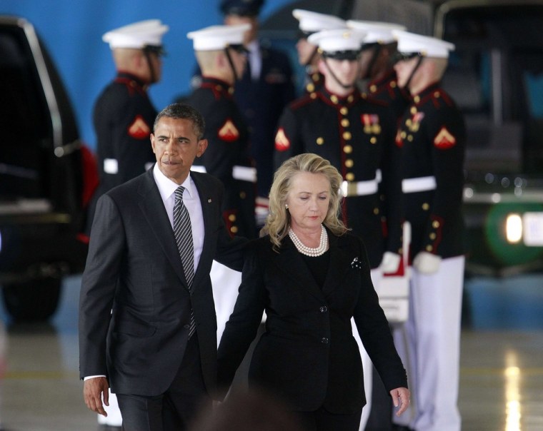 President Barack Obama walks with Secretary of State Hillary Clinton past the flag-draped transfer case of one of four Americans who died this week in Libya, during a transfer of remains ceremony at Andrews Air Force Base, Sept. 14.
