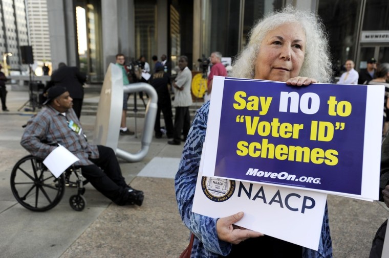 Gloria Gilman holds a sign during the NAACP voter ID rally to demonstrate her opposition to Pennsylvania's new voter identification law, Thursday, Sept. 13, 2012, in Philadelphia.