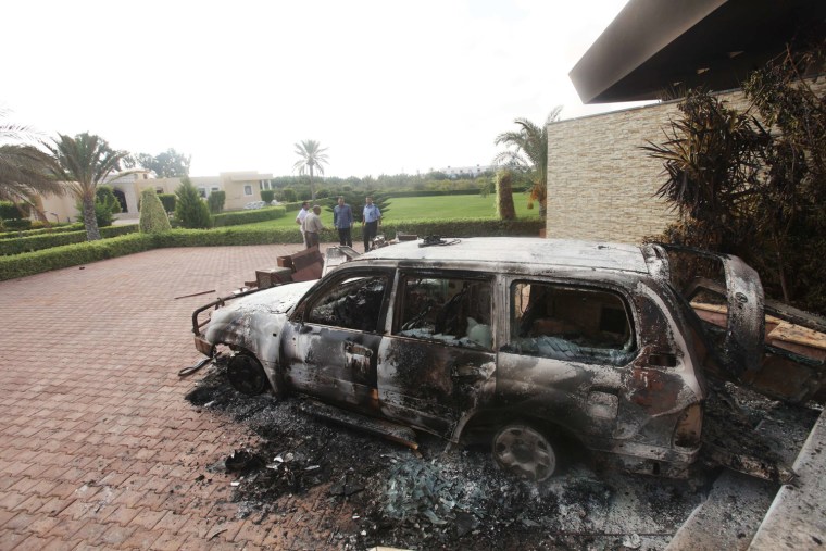 PHOTOBLOG: People stand near a burnt car at the U.S. consulate in Benghazi, Libya.