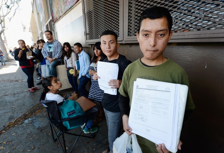 Roberto Larios, 21, right, holds Deferred Action for Childhood Arrival application as he waits in line with hundreds of fellow undocumanted immigrants at the Coalition for Humane Immigrant Rights of Los Angeles offices to apply for deportation reprieve...