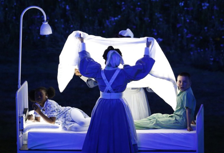 Actors lying on beds meant to represent Britain's National Health Service (NHS) perform during the 2012 Olympics in London.